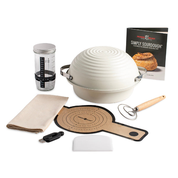 Baking kit with a dough ball, measuring cup, towel, and other tools on a white background