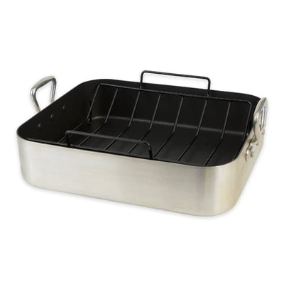 Stainless steel roasting pan with black interior rack on a white background