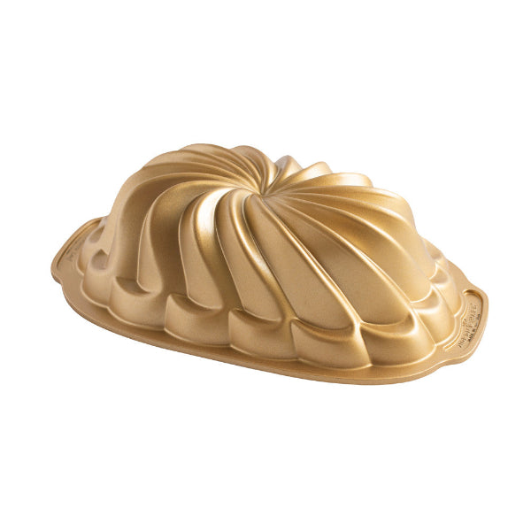 Gold Bundt cake mold on a white background