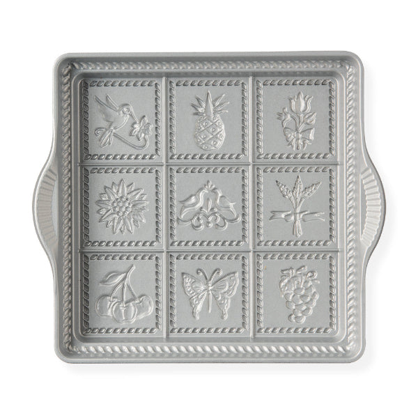 Decorative metal tray with embossed designs on a white background