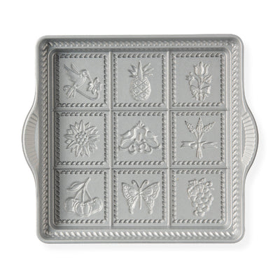 Decorative metal tray with embossed designs on a white background